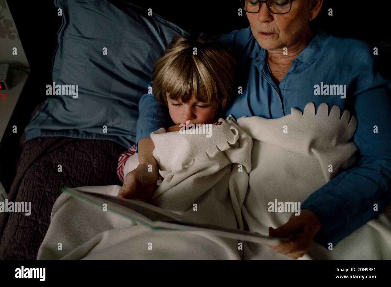 High-Angle-Ansicht der Großmutter Lesen Geschichte Buch für Enkel Auf dem Bett zu Hause Stockfoto