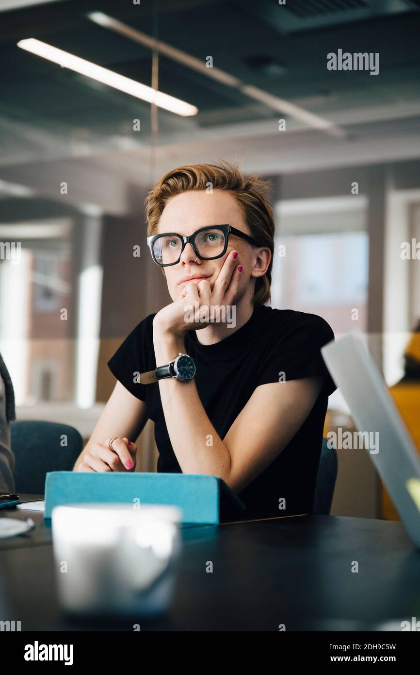 Geschäftsfrau, die im Konferenzraum mit einem Kollegen von Transgender über einen Laptop spricht Während des Meetings Stockfoto