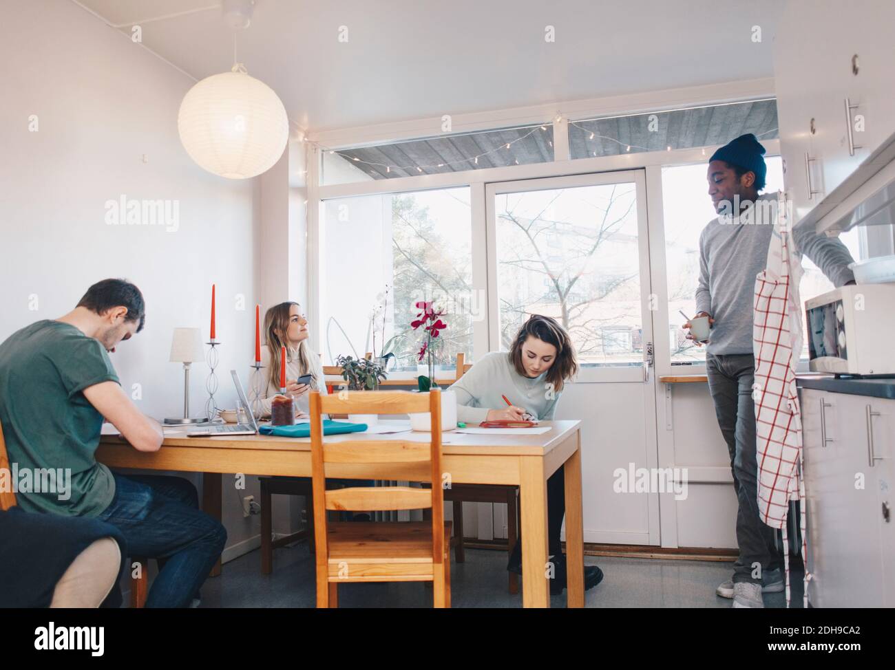 Freunde im Studieren und im Gespräch im Studentenwohnheim Zimmer Stockfoto