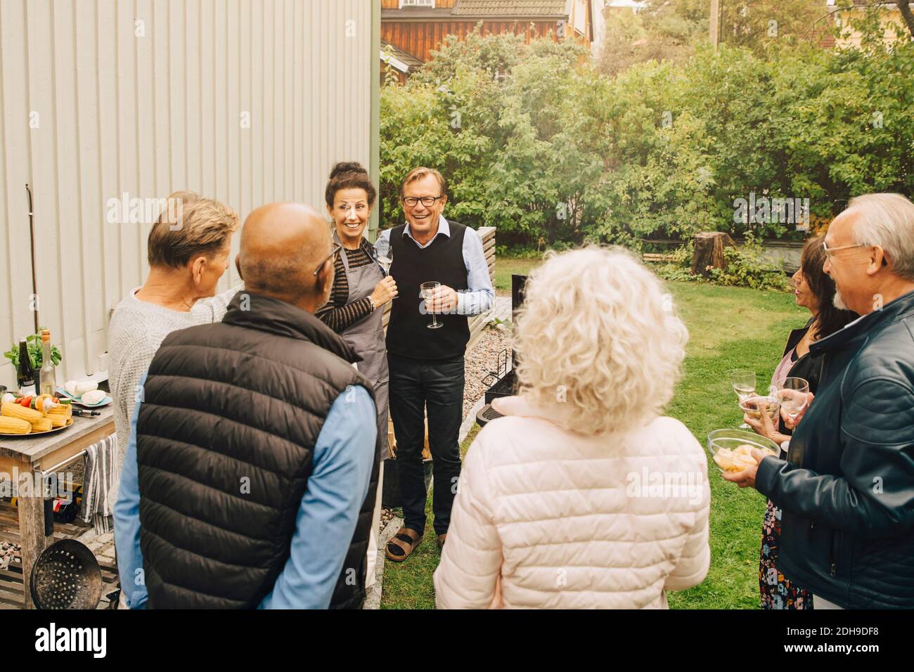 Glückliche männliche und weibliche aktive Senioren genießen während Gartenparty Stockfoto