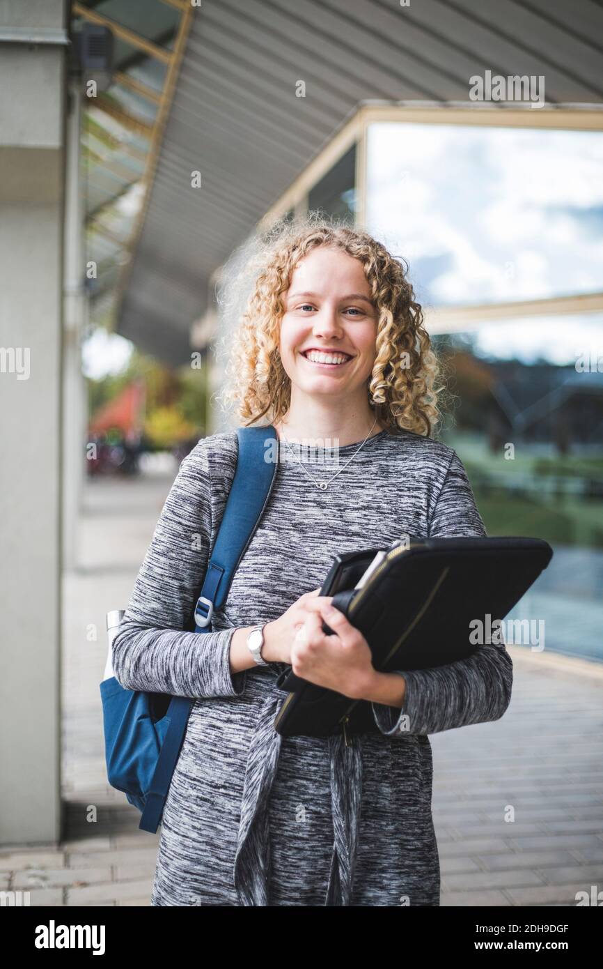 Porträt einer lächelnden jungen Frau an der Universität Stockfoto