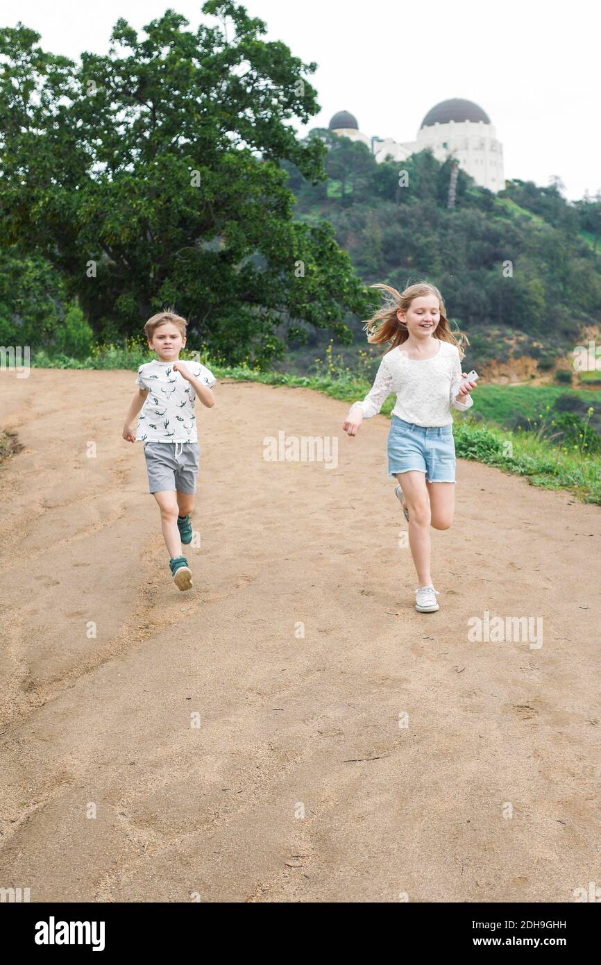 Die ganze Länge von Bruder und Schwester läuft auf Feldweg Stockfoto