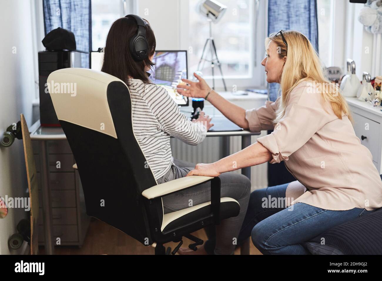 Mutter und Tochter diskutieren über Videospiel auf Computer-Bildschirm Zu Hause Stockfoto