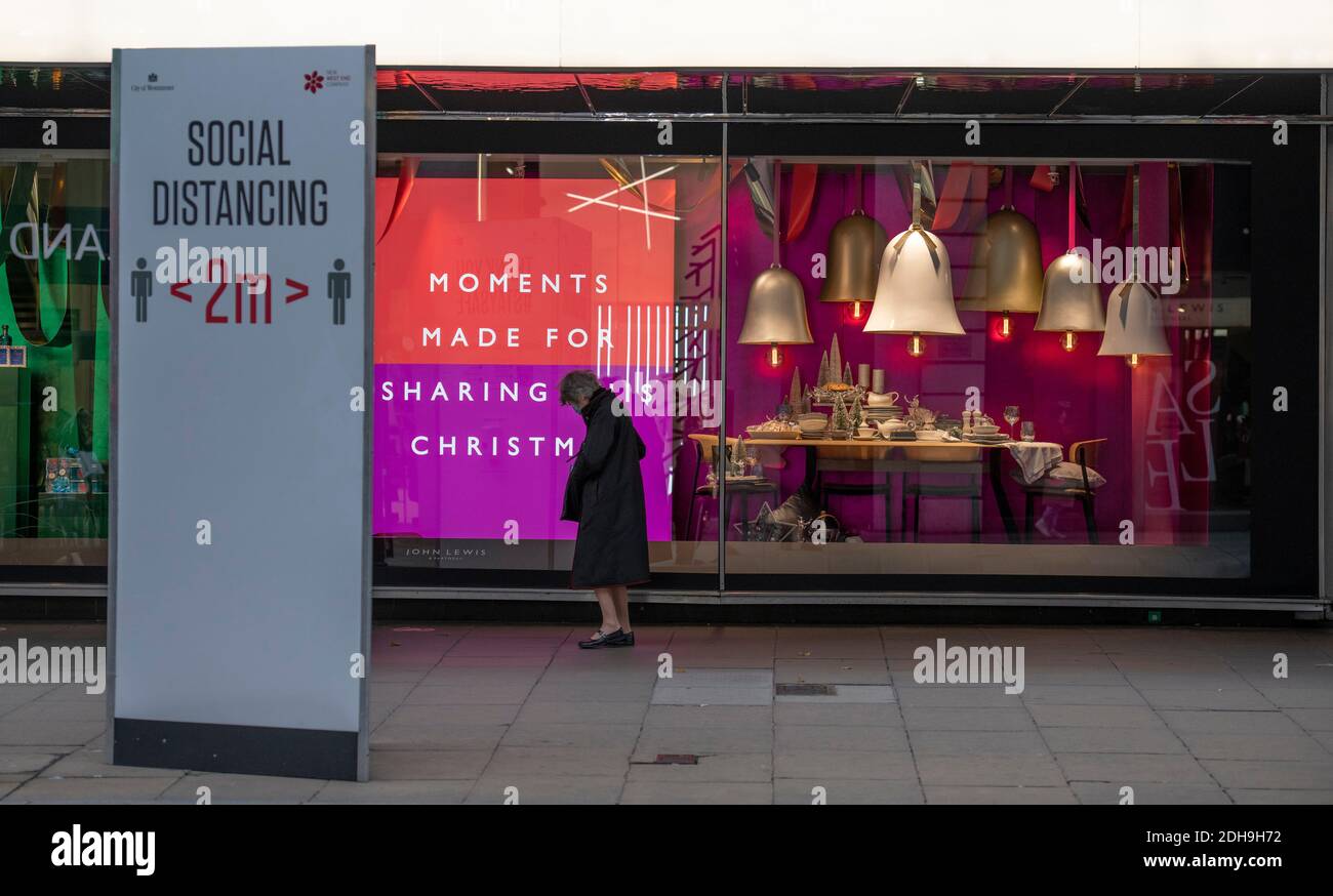 Oxford Street, London, Großbritannien. 10 Dezember 2020. Soziale Distanzierung Straßenschild und Sharing Poster in John Lewis. Quelle: Malcolm Park/Alamy Live News. Stockfoto