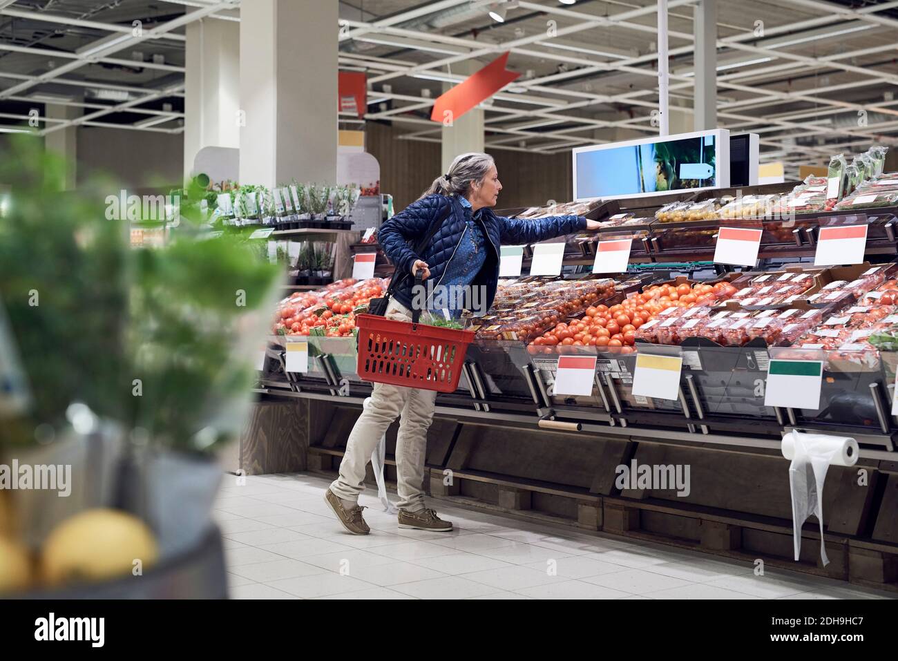 Frau kauft Gemüse aus dem Supermarkt Stockfoto