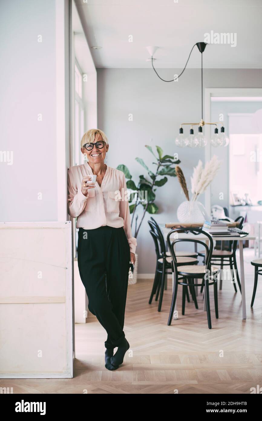 Porträt einer Frau, die zu Hause eine Kaffeetasse hält Stockfoto