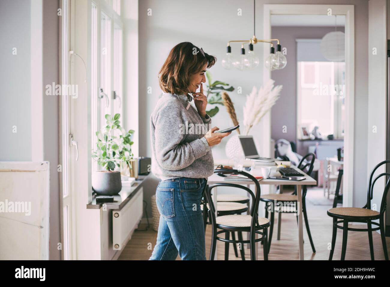 Glückliche Frau zu Hause, die am Telefon spricht Stockfoto