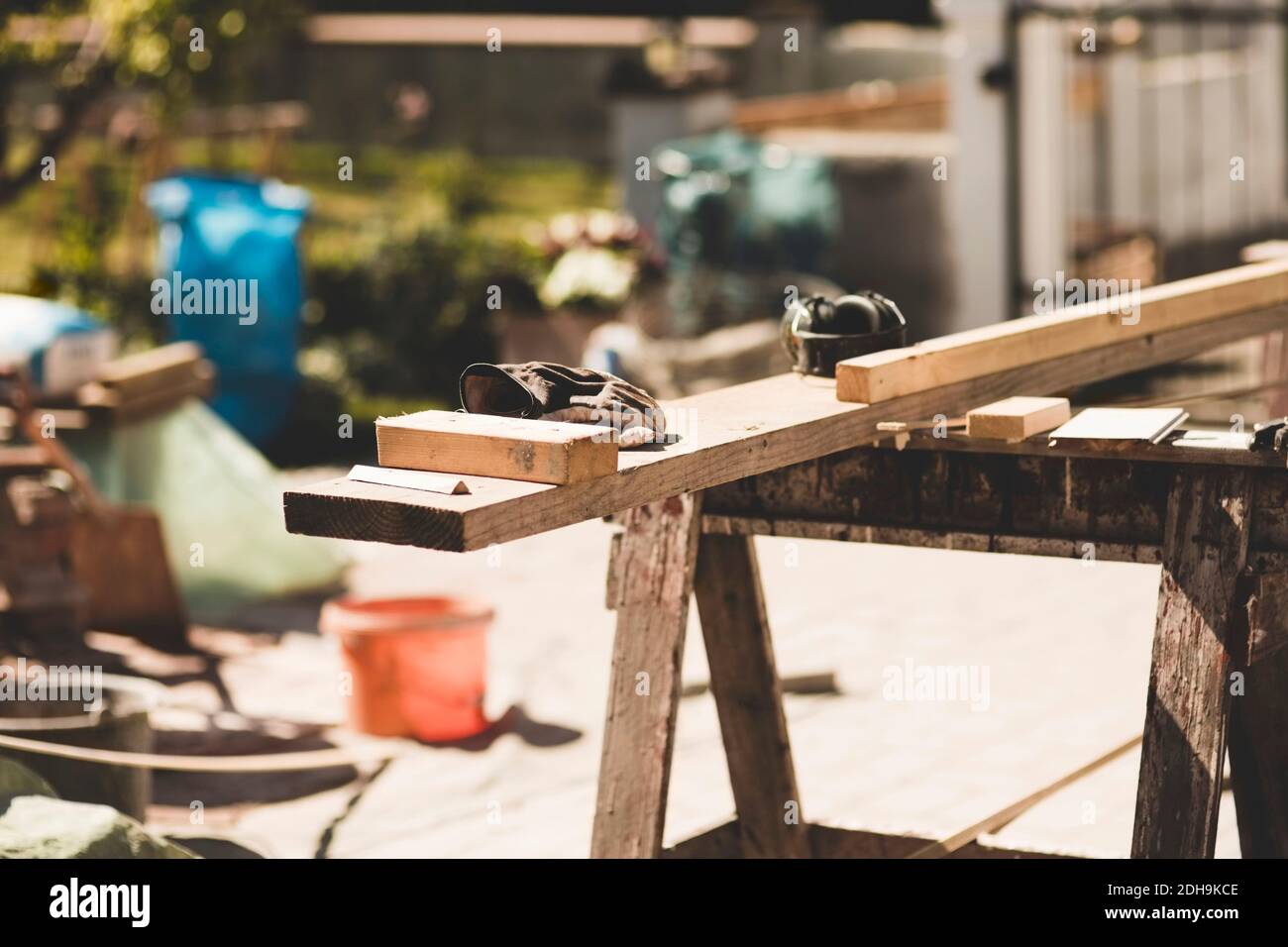 Holzbretter und Handschuhe im Hof während sonnigen Tages Stockfoto