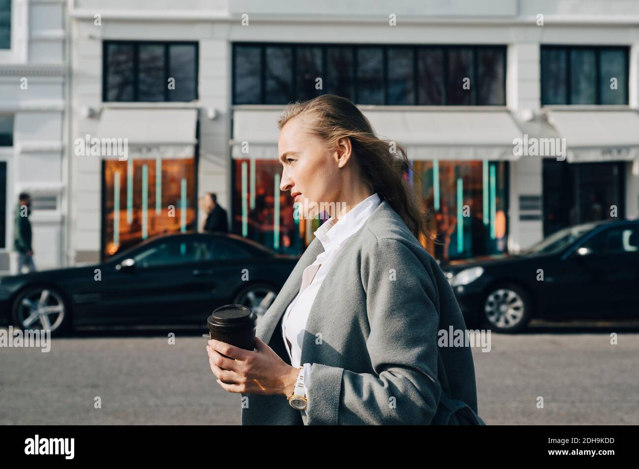 Seitenansicht der Betrachtung Unternehmer mit Einweg-Tasse wegschauen Während Sie in der Stadt stehen Stockfoto