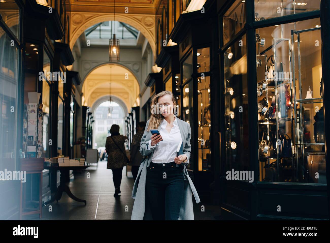 Erwägen Geschäftsfrau mit Smartphone, während in der Stadt stehen Stockfoto
