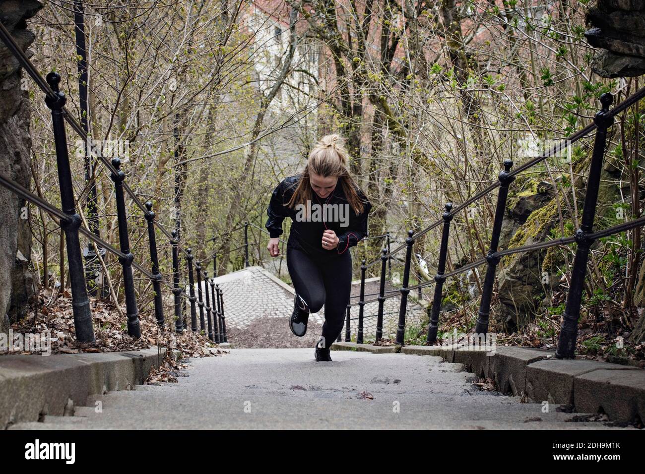 Volle Länge der fit Frau, die Treppe hinauf Stockfoto