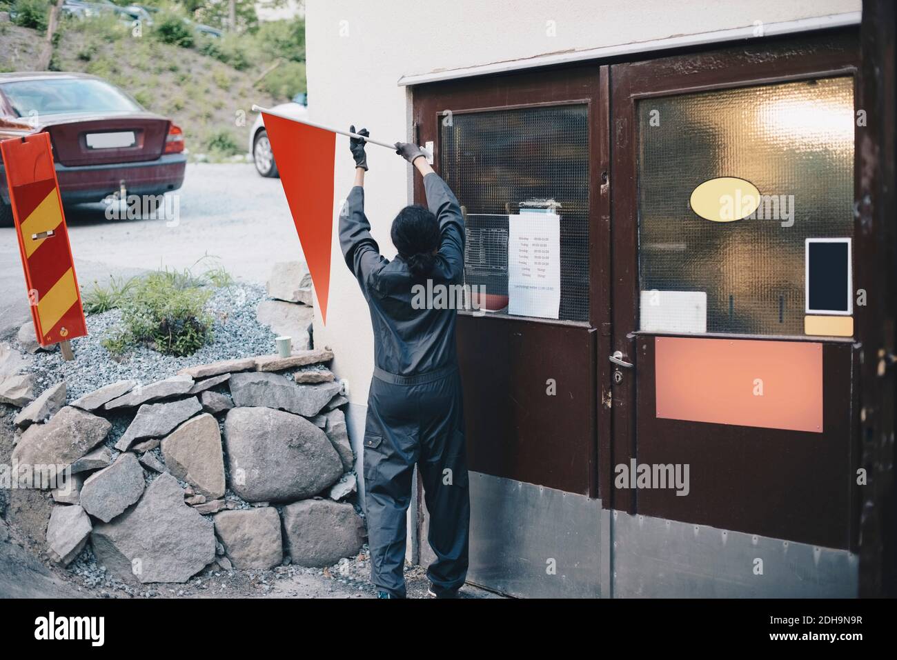 Rückansicht der mechanischen Buchse mit orangefarbener Flagge an der Tür Der Autowerkstatt Stockfoto