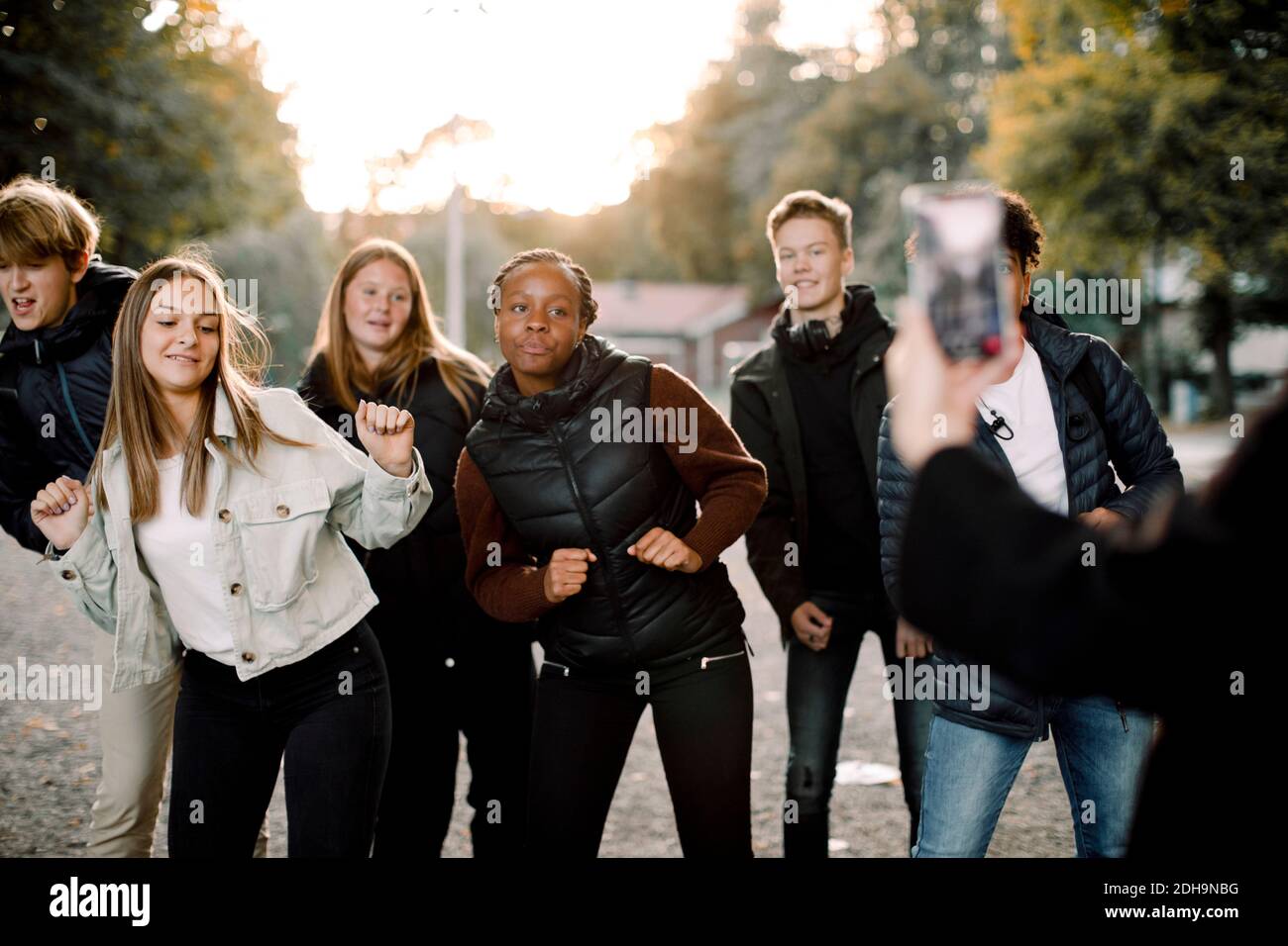 Frau, die Teenager-Mädchen und Jungen filmt, die auf der Straße tanzen Stadt Stockfoto