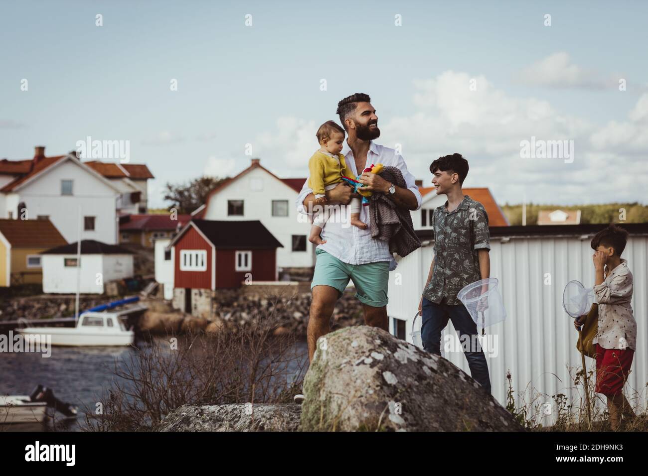 Vater mit Kindern, die wegschauen, während sie auf dem Archipel stehen Stockfoto