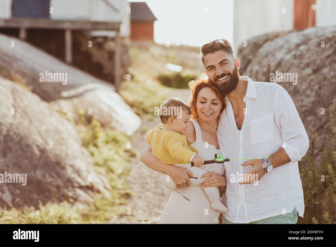 Portrait von lächelnden Vater steht bei Frau trägt Baby Mädchen Über dem Archipel Stockfoto
