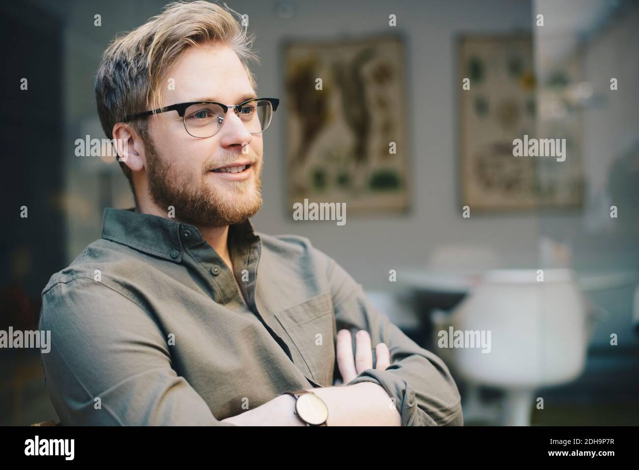 Nachdenkliche männliche Computer-Programmierer stehende Arme im Büro gekreuzt Stockfoto