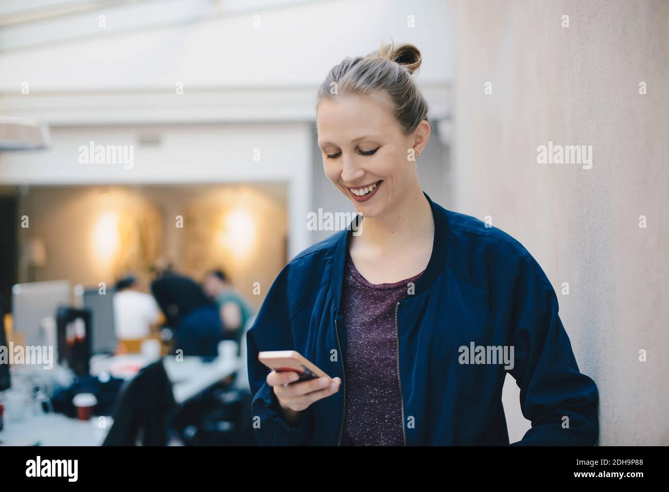 Glückliche weibliche Computer-Programmierer mit Smartphone im kreativen Büro Stockfoto