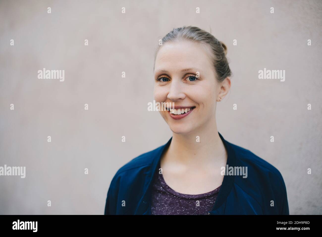 Porträt von glücklichen weiblichen Computer-Programmierer gegen beige Wand in Büro Stockfoto
