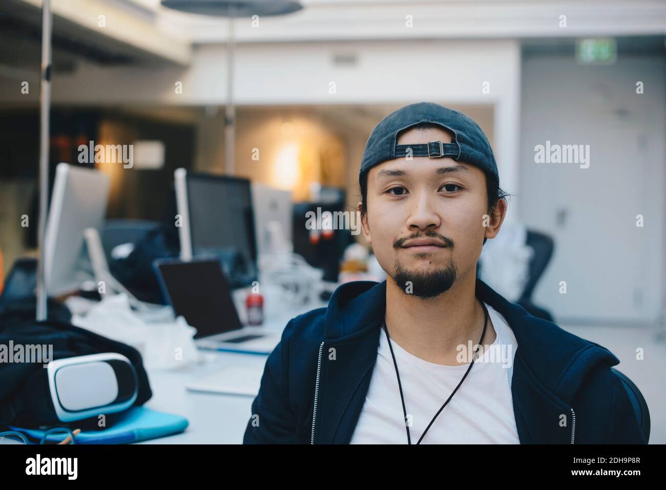 Portrait von selbstbewussten Computer-Programmierer tragen Kappe im Büro Stockfoto