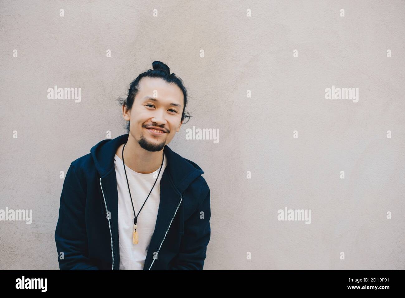 Portrait von lächelnden männlichen Computer-Programmierer gegen beige Wand in Büro Stockfoto