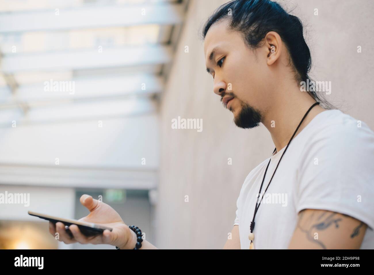 Low-Angle-Ansicht von Computer-Programmierer mit Smartphone in Büro Stockfoto