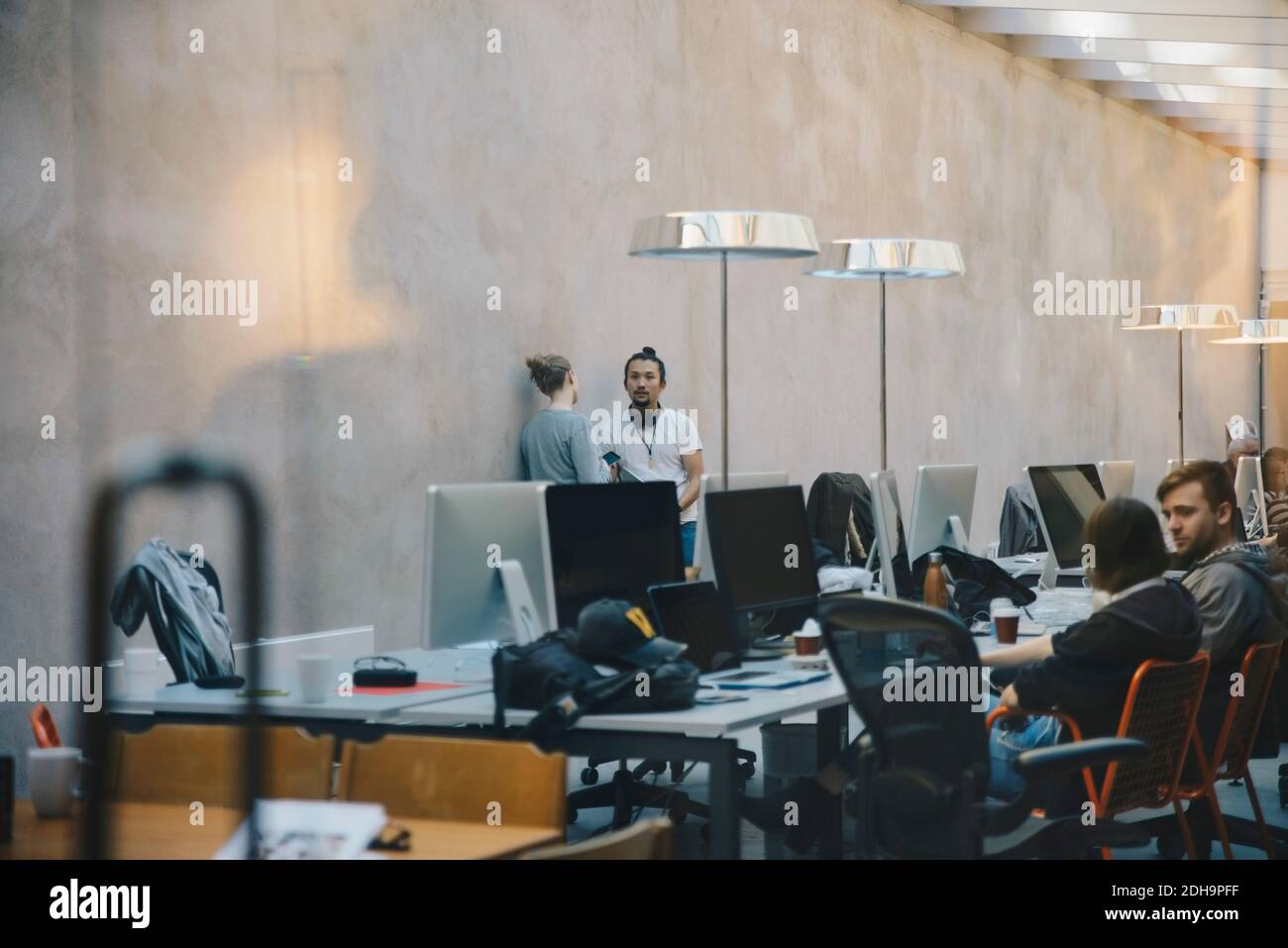 Männliche und weibliche Computerprogrammierer diskutieren im kreativen Büro Stockfoto