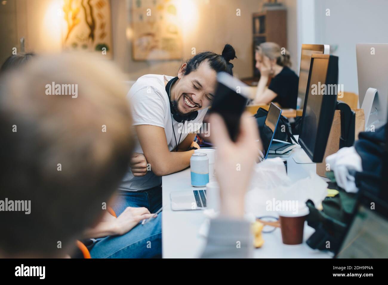 Happy Computer Programmierer sitzen mit Kollegen am Schreibtisch im Büro Stockfoto