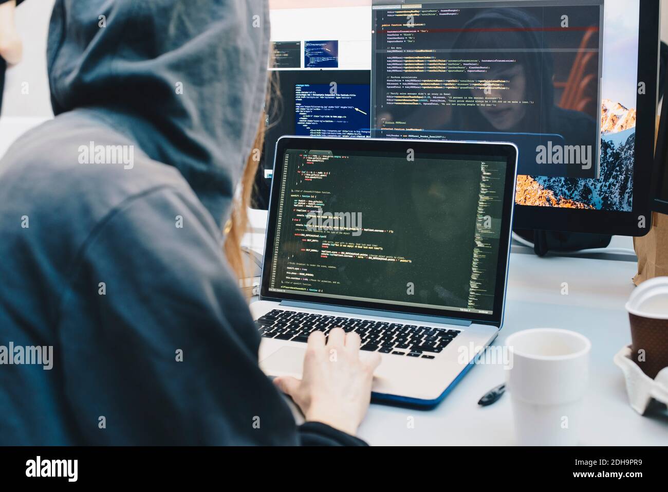 Seitenansicht des Computerprogrammierers, der auf Laptop am Schreibtisch programmiert Im Büro Stockfoto