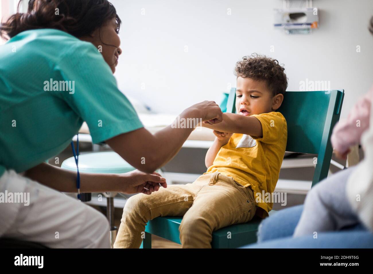 Ärztin zeigt auf den Arm des Jungen im Krankenhaus Stockfoto