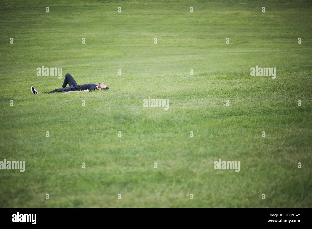 Mittlere Sicht auf den Mann, der über Gras liegt Stockfoto