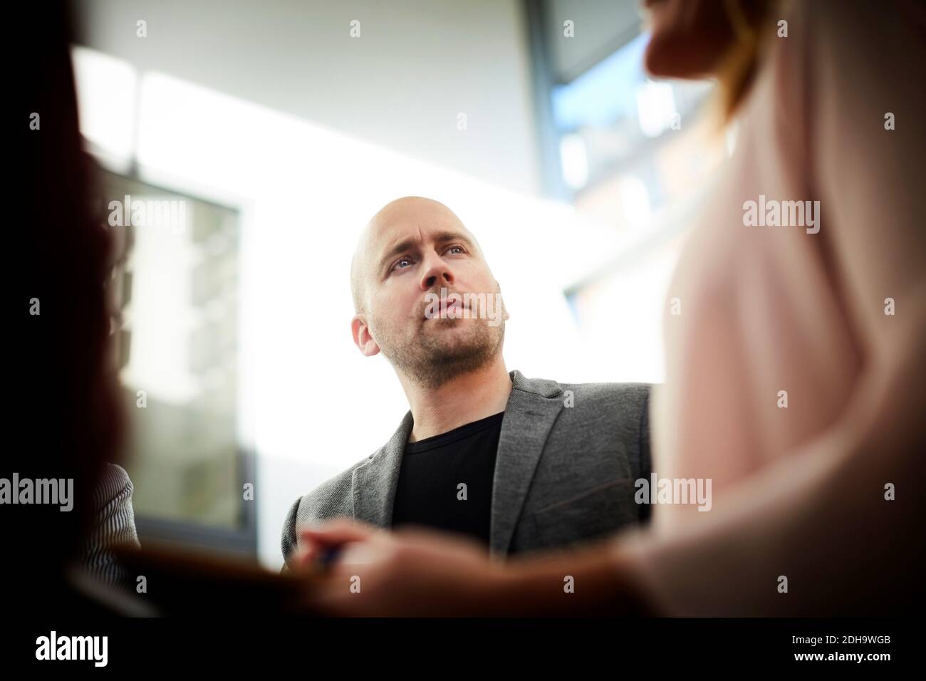 Verwirrt Geschäftsmann Blick auf weibliche Mitarbeiter in Office-Meeting Stockfoto