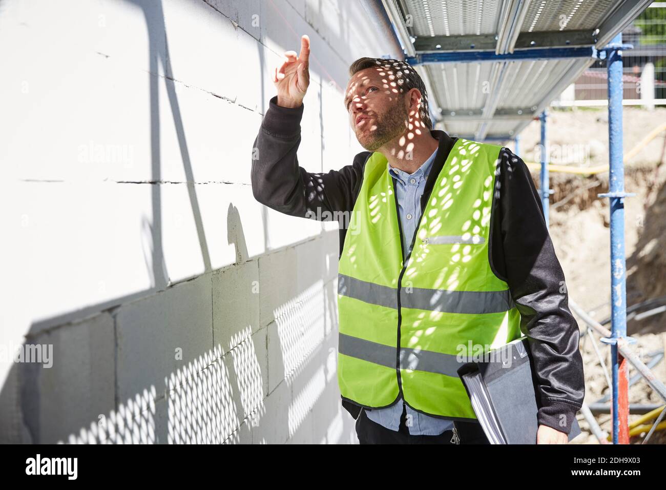 Architekt mit Datei-Analyse auf der Baustelle Stockfoto