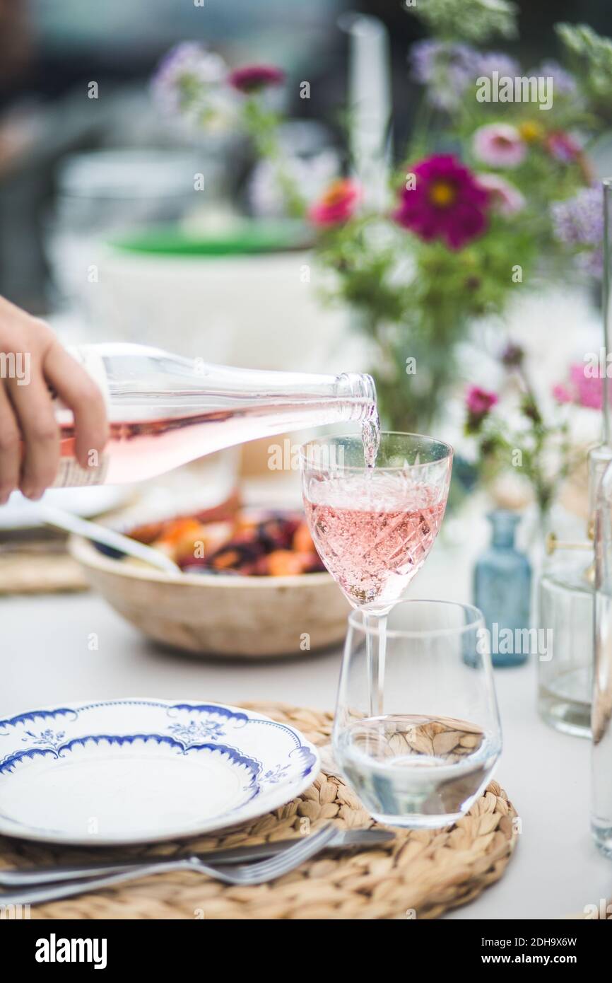 Kurze Hand Gießen Getränk in Glas während der Dinner-Party Stockfoto