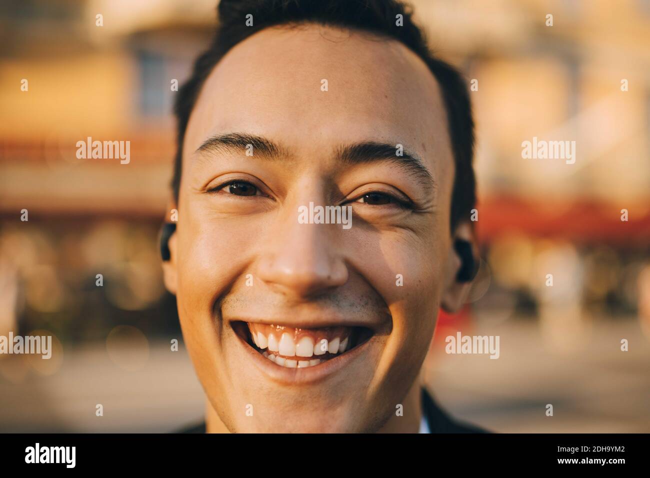 Nahaufnahme eines lächelnden jungen Mannes in der Stadt Stockfoto