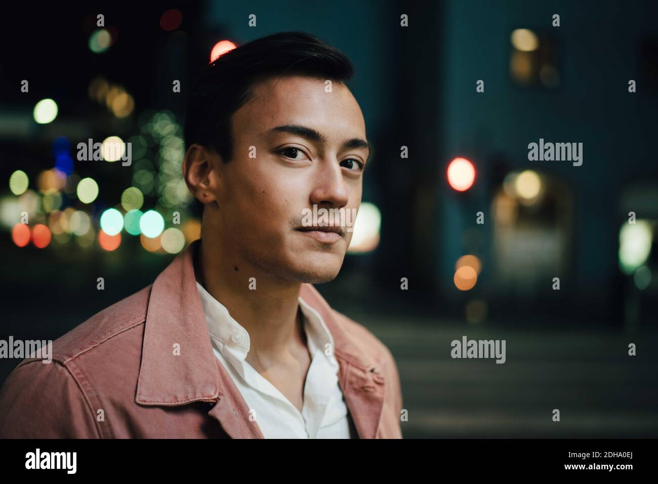 Portrait des modischen Mannes, der nachts in der Stadt steht Stockfoto