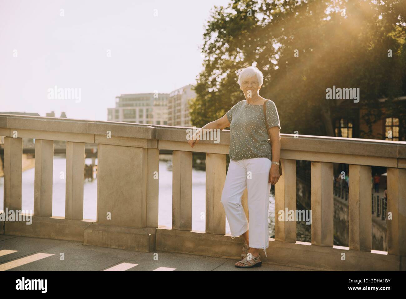 In voller Länge Porträt der älteren Frau auf Brücke gegen stehen Geländer in der Stadt Stockfoto
