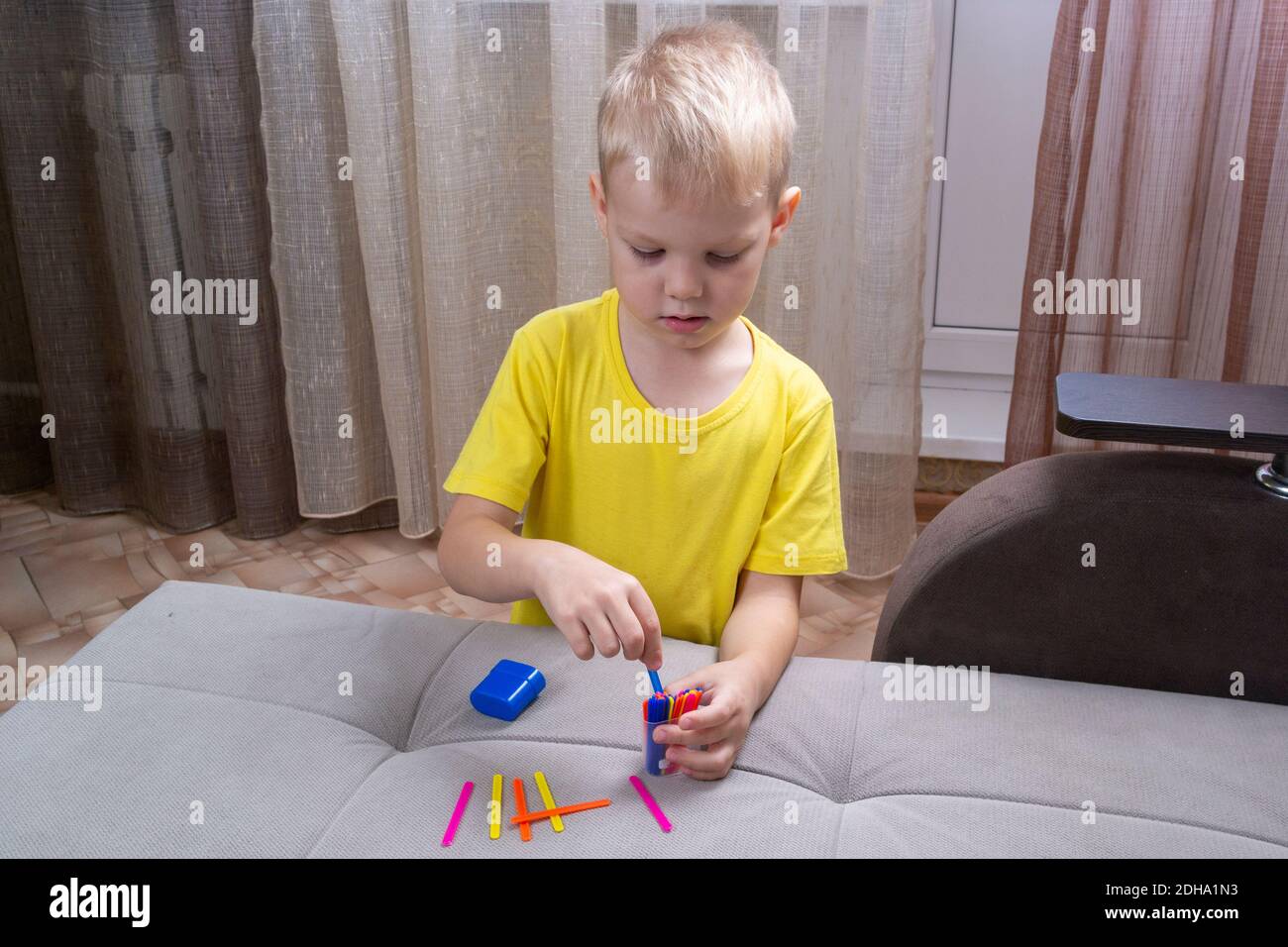 Kleiner Junge lernt mit Zählstöcken zu zählen Stockfoto