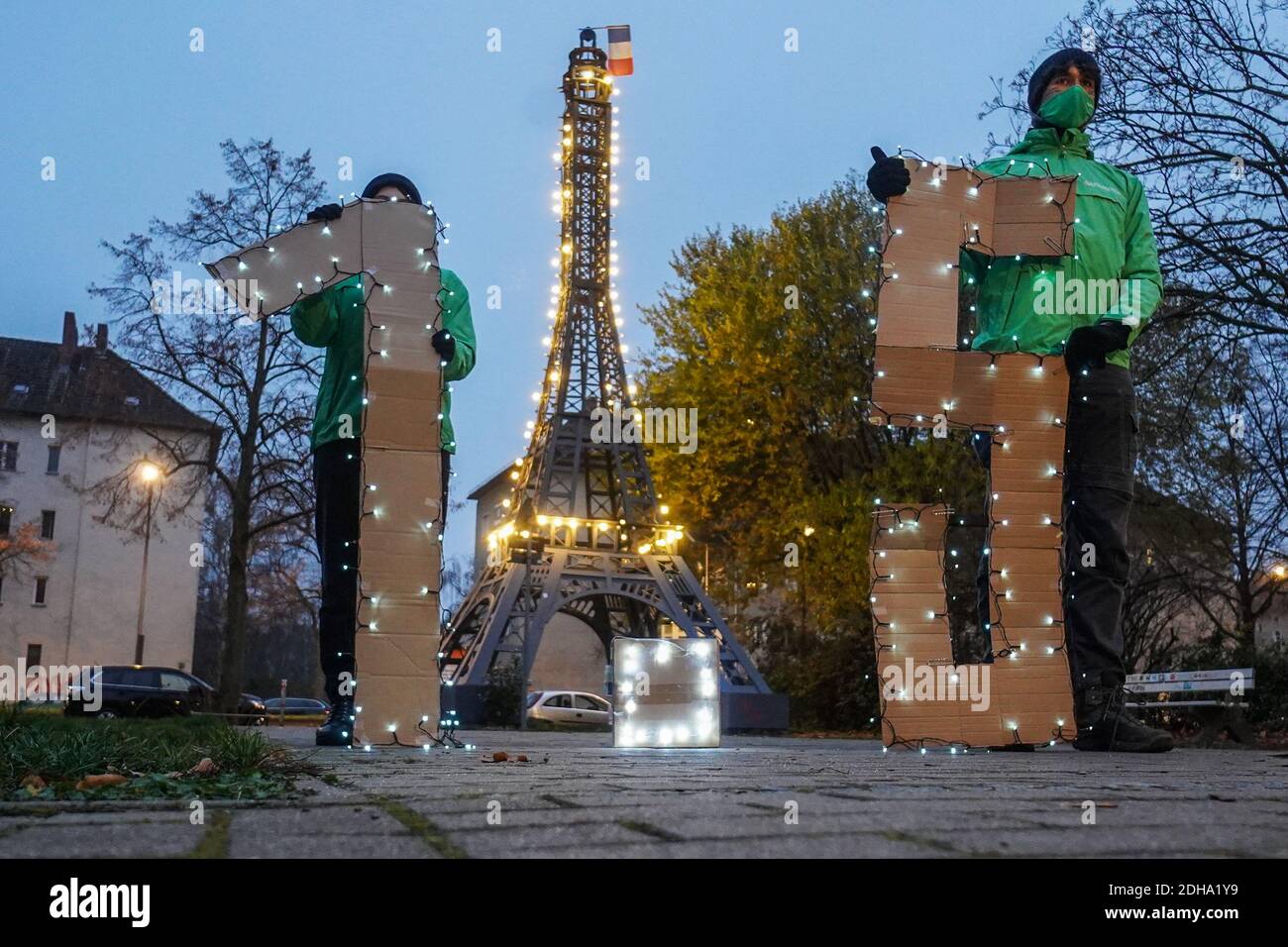 Berlin, Deutschland. Dezember 2020. Mitglieder der Greenpeace-Jugend halten bei einer Lichtaktion die Nummer "1.5" vor dem Miniatur-Eiffelturm im Centre Francaise. Die jungen Aktivisten fordern mehr Anstrengungen, um den Temperaturanstieg auf 1.5 Grad zu begrenzen - wie es die Pariser Klimakonvention anstrebt. Quelle: Jörg Carstensen/dpa/Alamy Live News Stockfoto