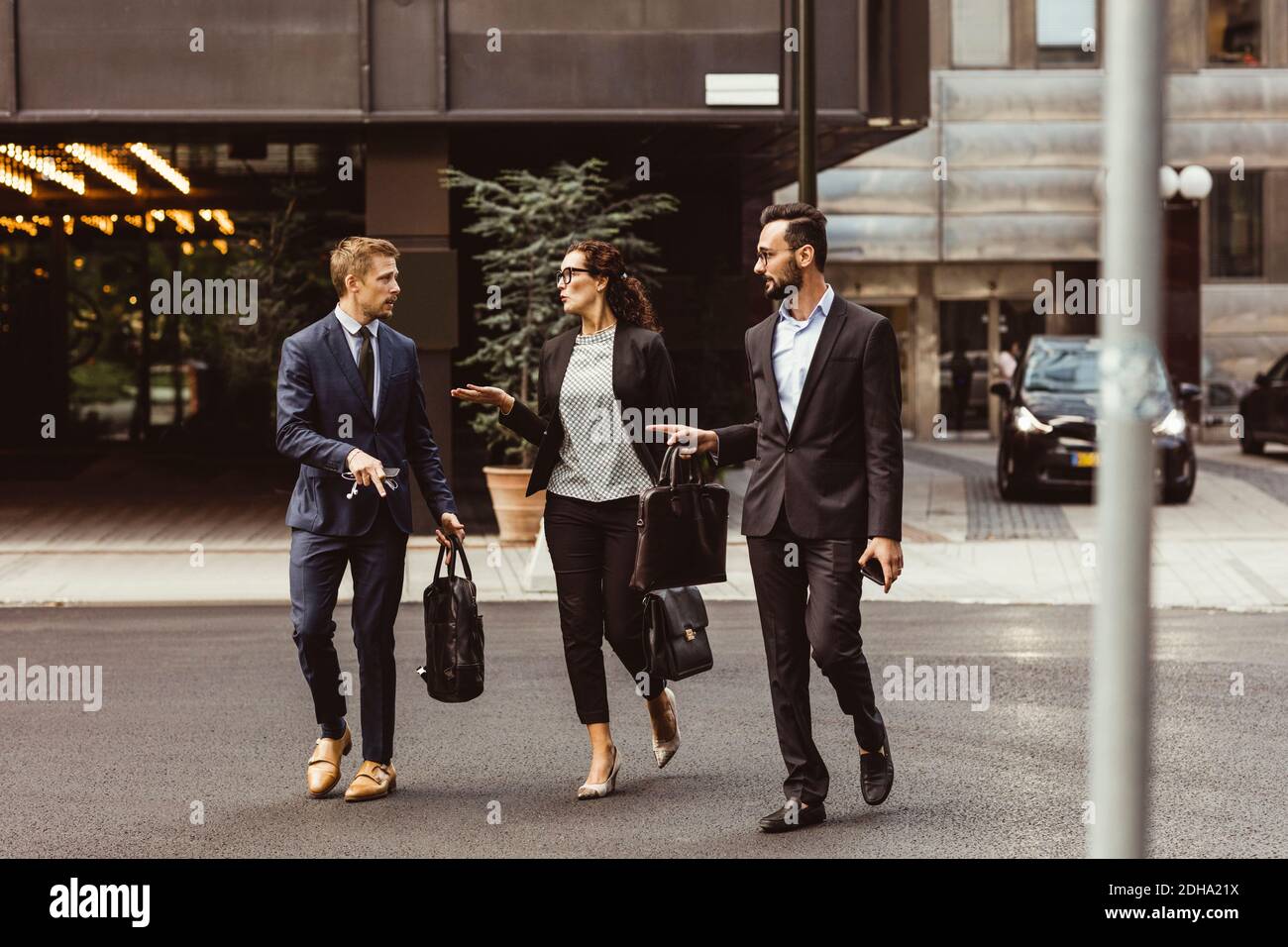 Männliche und weibliche Unternehmer diskutieren Geschäftsstrategie beim Gehen im Freien Stockfoto