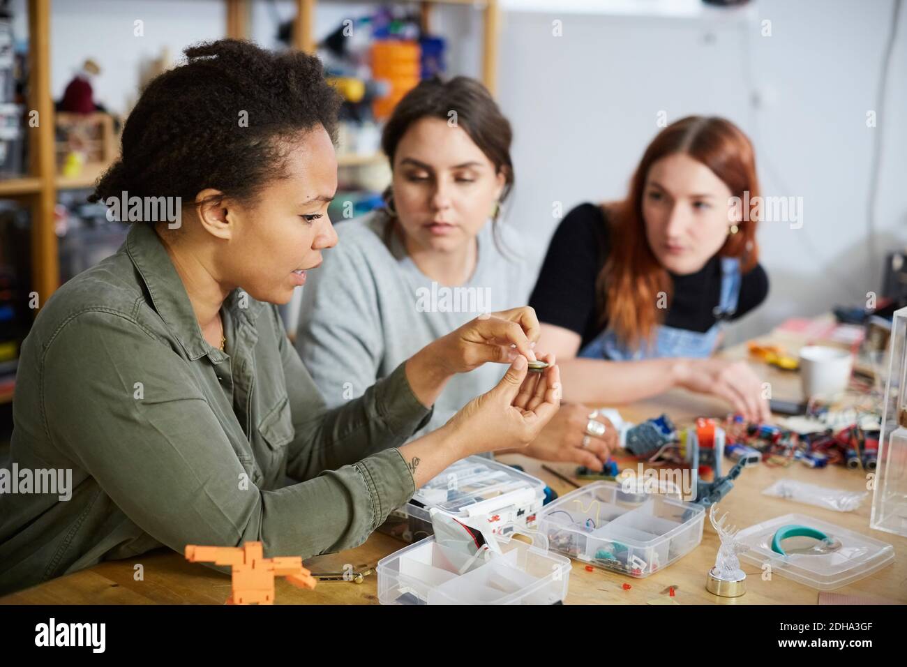 Techniker mit mittlerem Erwachsenenalter, die jungen Kolleginnen im Workshop erklärt Stockfoto