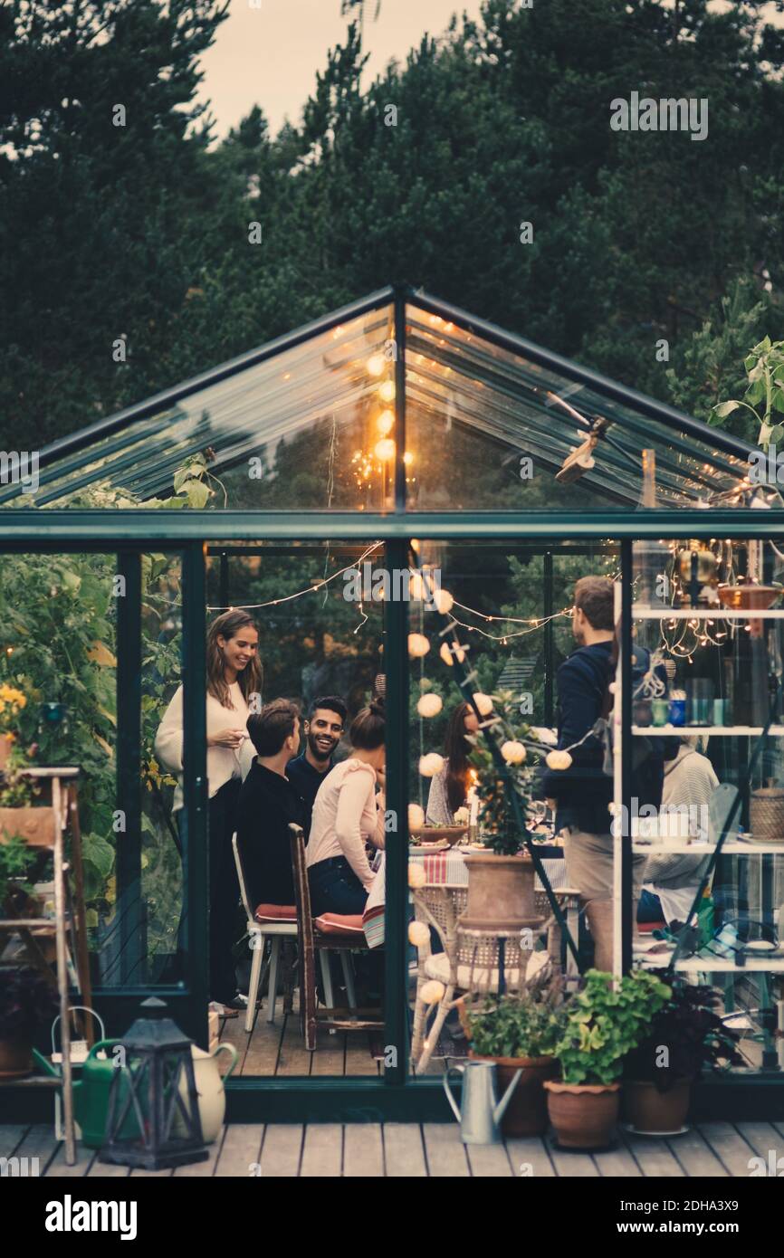 Glückliche junge multi-ethnische Gruppe genießen Abendessen Party im Wintergarten Hinterhof Stockfoto