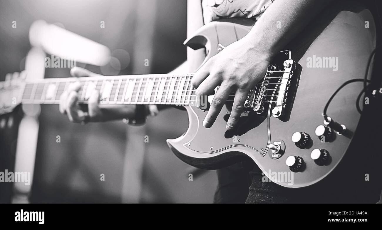 Schwarz-Weiß-Bild von professionellen Rock-Musiker spielen auf E-Gitarre Punk Rock Konzert. Musik. Stockfoto