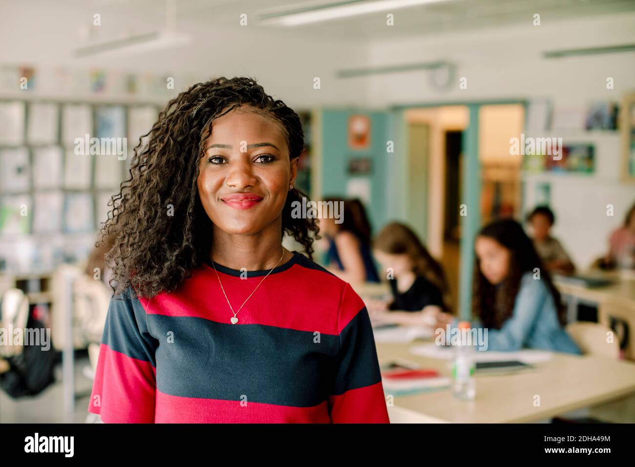 Porträt einer lächelnden weiblichen Tutorin, die im Klassenzimmer steht Stockfoto