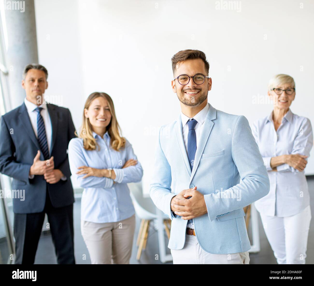 Gruppe von Geschäftsleuten, die zusammen im Büro mit stehen Ihr junger Bussinesführer Stockfoto