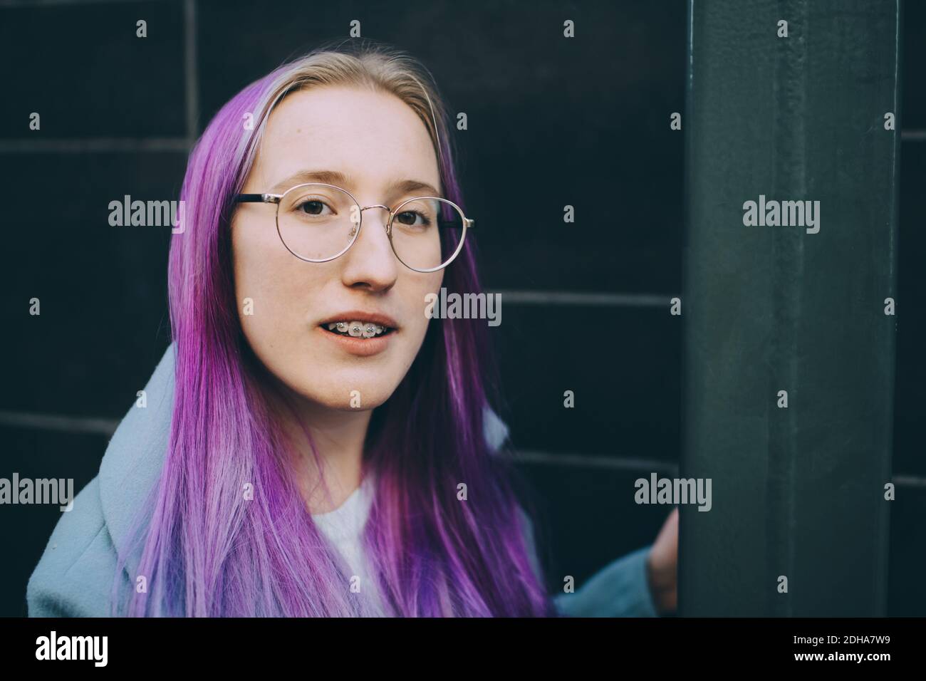 Portrait von Teenager-Mädchen mit Hosenträger an der Wand stehen Stockfoto