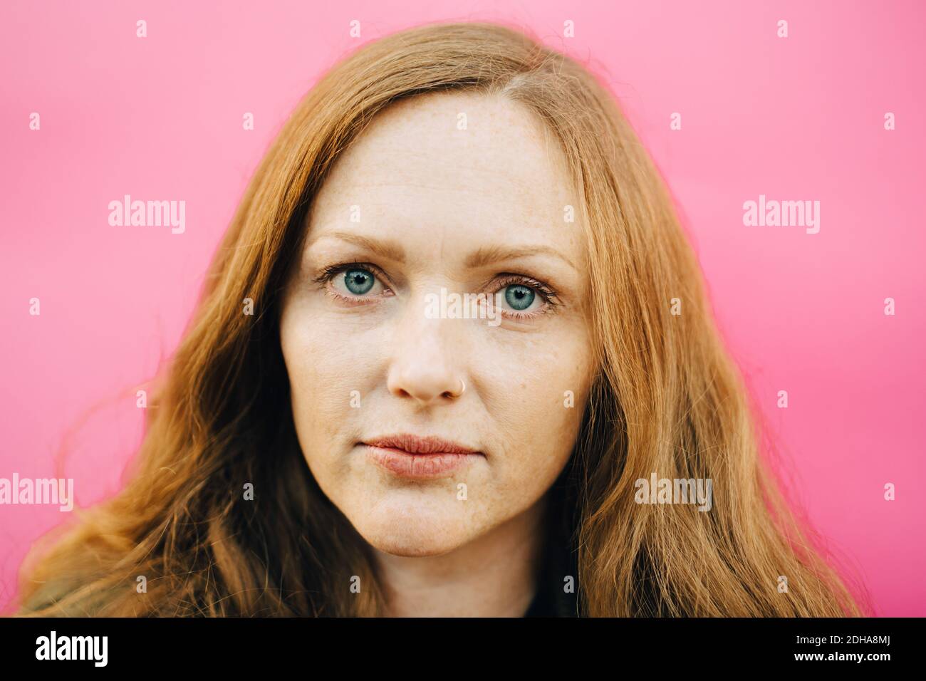 Porträt der mittleren erwachsenen Frau auf rosa Hintergrund Stockfoto