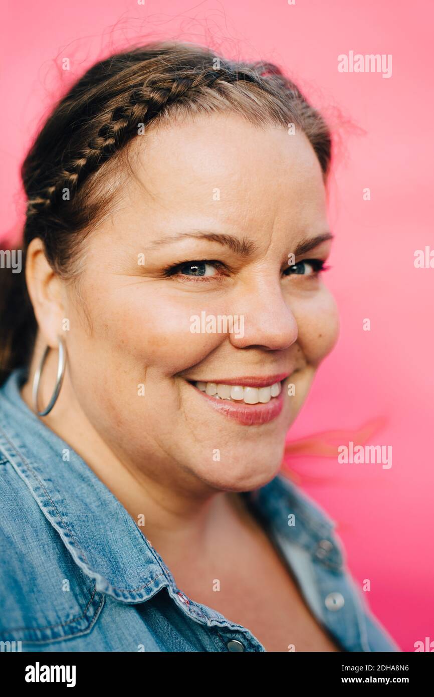 Portrait von glücklichen reifen Frau vor rosa Hintergrund Stockfoto