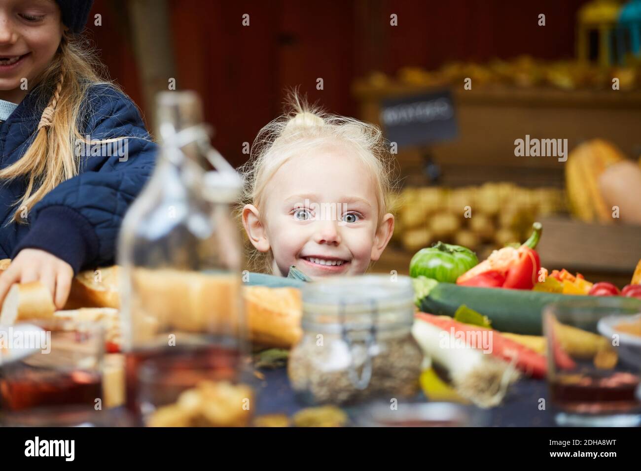 Portrait des lächelnden Mädchen sitzt von weiblichen Geschwister am Tisch Im Hinterhof Stockfoto