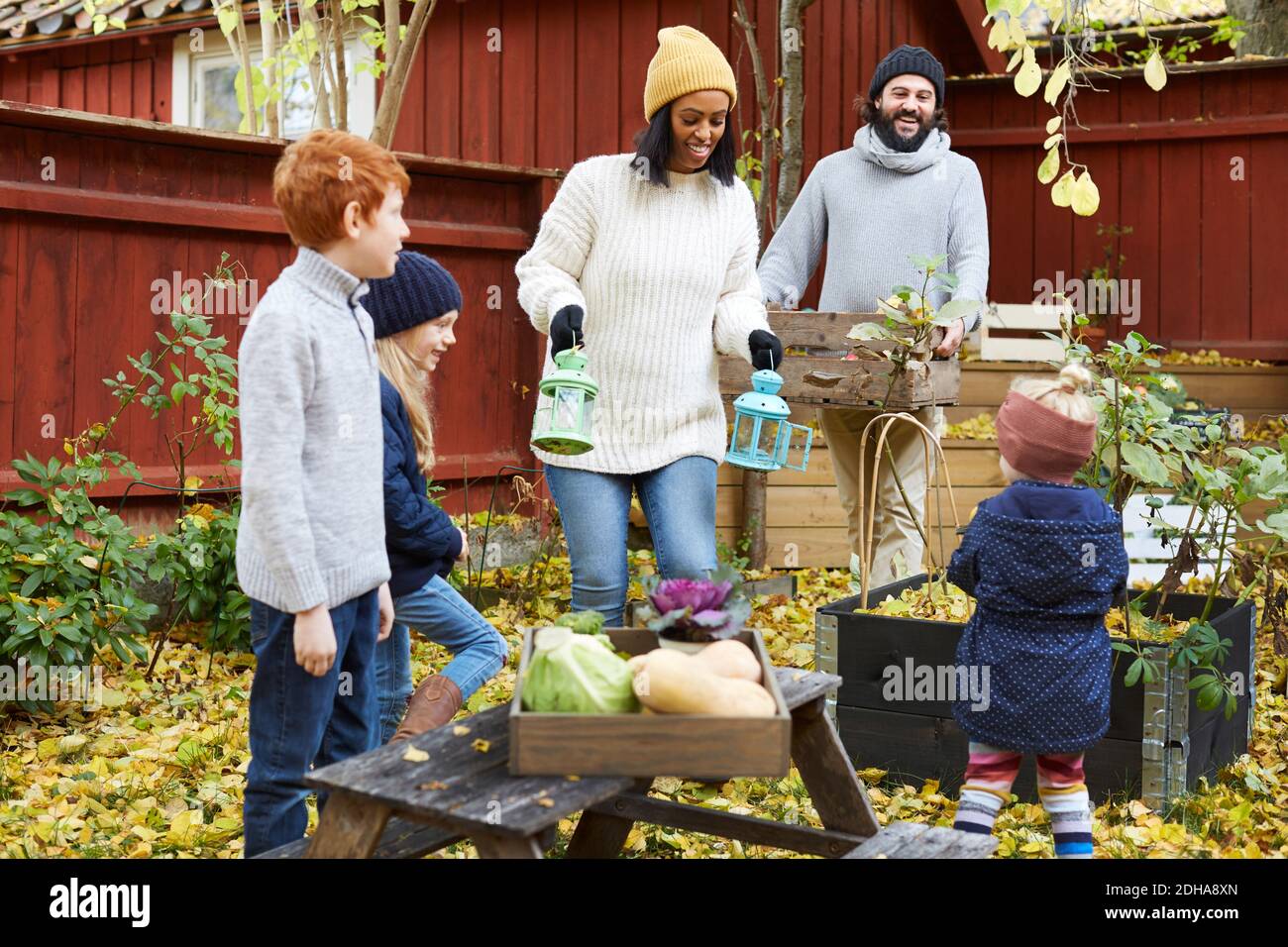 Männliche und weibliche sammeln frische Produkte aus dem Garten, während Kinder Steht im Hof Stockfoto