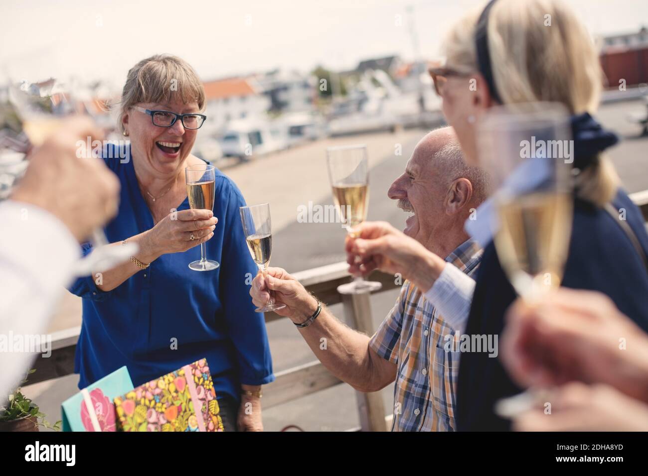 Fröhliche ältere Frau, die mit Freunden im Restaurant Sektflöte toaste Terrasse Stockfoto